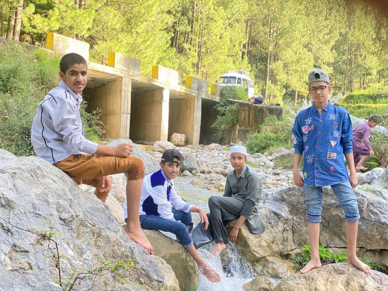 Children from Ashiana-e-Korang on an outdoor outing near a mountain stream